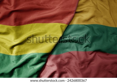 big waving national colorful flag of lithuania and national flag of bolivia . macro