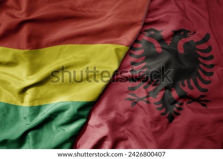 big waving national colorful flag of albania and national flag of bolivia . macro