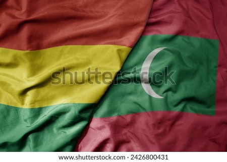 big waving national colorful flag of maldives and national flag of bolivia . macro