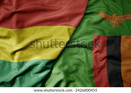 big waving national colorful flag of zambia and national flag of bolivia . macro