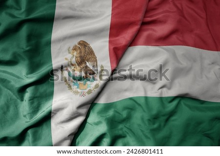 big waving national colorful flag of hungary and national flag of mexico . macro