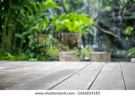 Empty wood table top with blur green tropical garden background for product display