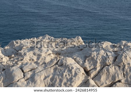 Close-up shot of the white limestone of the Calanques in Marseille, Les Goudes, France. Minimalism, minimalist picture. Mediterranean sea in the background.