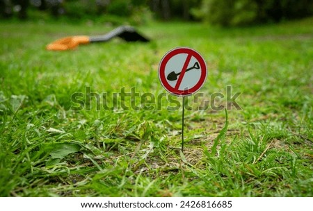 A sign on the lawn forbidding digging.Prohibition of archaeological excavations. A shovel on a round sign.