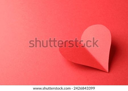 One paper heart on red background. Space for text