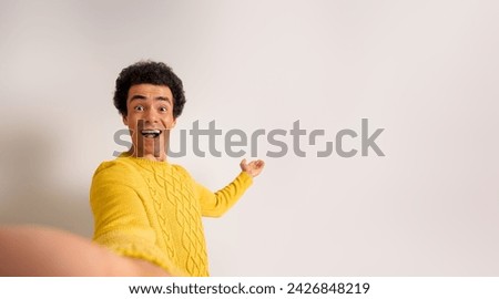 Portrait of excited young salesman advertising new product on copy space over white background