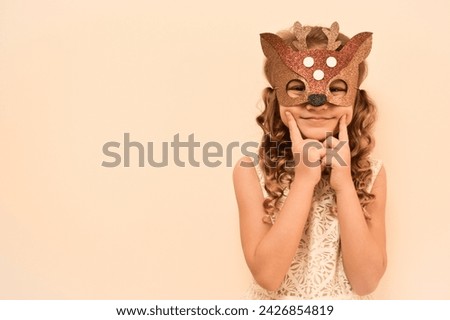 Unique child. Happy child in deer costume. Little cute girl in a carnival masquerade deer mask made of foamiran. The child is preparing to celebrate festival. Royalty-Free Stock Photo #2426854819