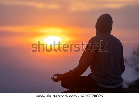 Back view of man is relaxingly practicing meditation yoga mudra at mountain top with sunrise during winter to attain happiness from inner peace wisdom for healthy mind and soul Royalty-Free Stock Photo #2426878099
