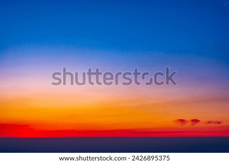 Spectacular sky with clouds at sunset as a background; the beginning of the blue hour after the sun sets below the horizon Royalty-Free Stock Photo #2426895375