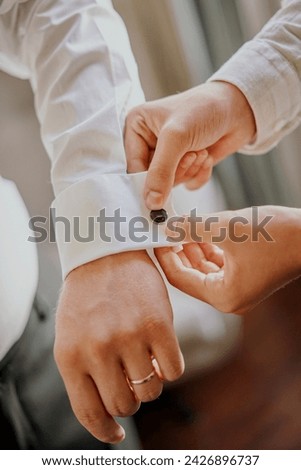 Cufflinks wearing background. Dressing up the groom. Wedding preparation background. White shirt for business meeting. stock photo