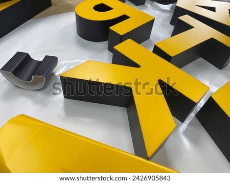 Three-dimensional light letters in yellow.Production of a logo for a company in the production of outdoor advertising.