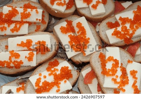 Sandwiches with red caviar and fish on bread. High quality stock photo of snacks.