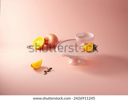 A white cake stand against light pink background. With slice orange and peach. An empty platform for display cosmetic products, food and props. Royalty-Free Stock Photo #2426911245