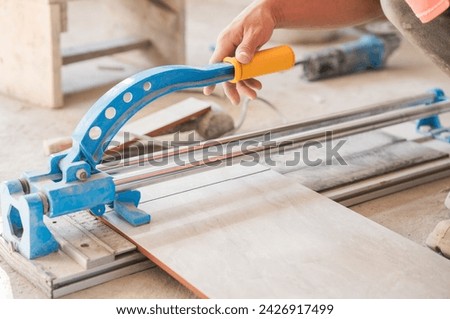 Hand tiler cutting tile with cutter tool equipment 