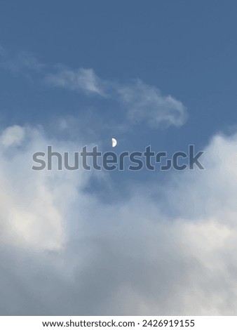 Half Moon amid bright clouds