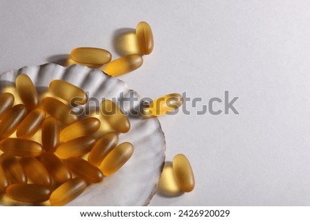 everyday supplements, wellness, multivitamin, healthy lifestyle concept. Vitamins Omega 3 on shell on white background. copy space. Royalty-Free Stock Photo #2426920029