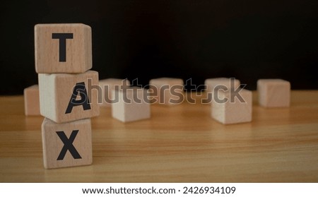 Woman hand hold wooden block with tax icon for income tax return and submit for payment. Calculation return, vat, personal income tax, tax payment. Business and finance concept, spending.