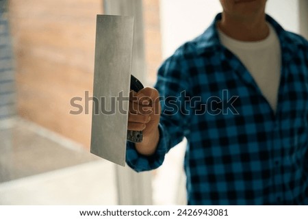 Cropped picture of workman hand holding float trowel