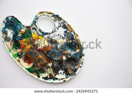 Palette with bright colours on white background. Abstract art. Paint palette with copy space. Drawing hobby. Mix of various colours. Creative design. Inspiration ideas. Vibrant texture.