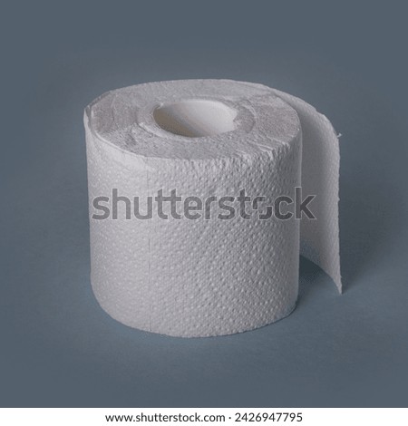 a roll of white perforated toilet paper, isolate on a blue background