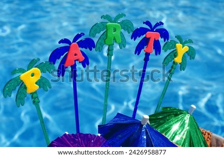 Party on the background of the blue pool. Festive decor umbrellas, tinsel, palm trees, sparkles.