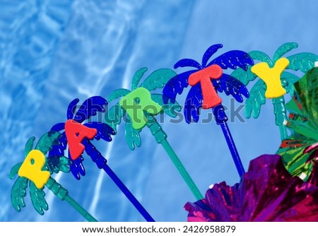 Party on the background of the blue pool. Festive decor umbrellas, tinsel, palm trees, sparkles.