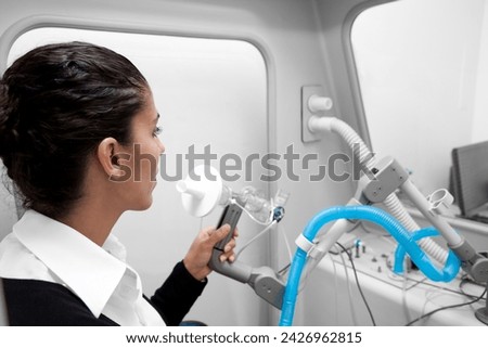 Young woman during a spirography test, measuring breathing movements with spirometer, spirometry. Diagnosis of respiratory function in pulmonary disease for Asthma, shortness of breath, bronchitis Royalty-Free Stock Photo #2426962815