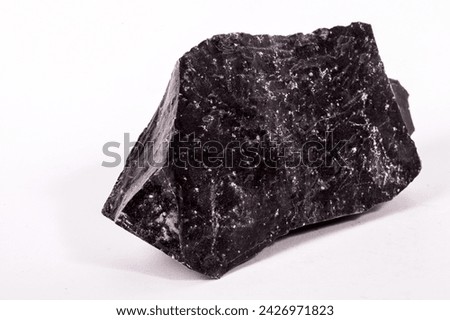 Meteorite black stone rock on background.
