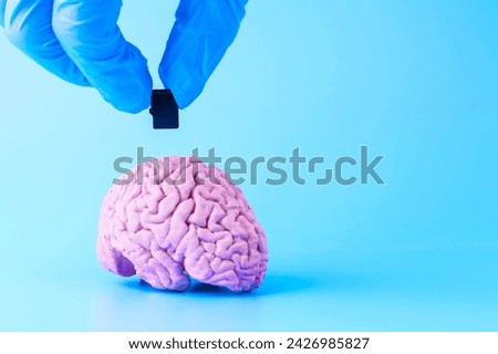 A man's hand inserts a flash card into the brain