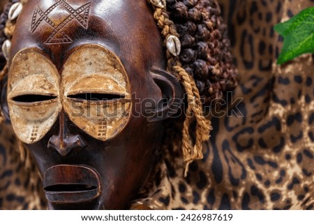 Wooden tribal African mask from Uganda, for family or personal protection, made of local wood, ropes and seashells as hair decoration