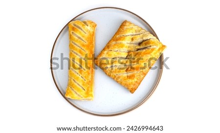 Overhead top down view of sausage roll and bake pastry Isolated on a plate. baked pastry with white background, no people and copy space. Golden yellow and brown pastry.