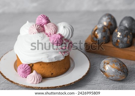 Beautiful stylish still life. Easter cake with meringue, marshmallows, Easter eggs and willow twigs on a light concrete background. happy Easter 2024.