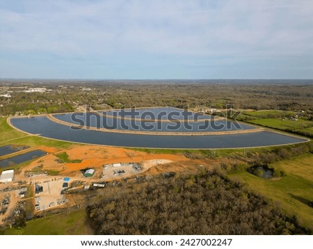 reservoir of non-standard shape in the city for cooling production Royalty-Free Stock Photo #2427002247