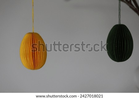 Easter Decoration. Green, yellow and white paper eggs hanging from beautiful naturally thin branches from birch. In Sweden it is often used as an Easter decoration. GoranOfSweden
