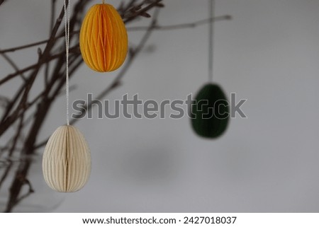 Easter Decoration. Green, yellow and white paper eggs hanging from beautiful naturally thin branches from birch. In Sweden it is often used as an Easter decoration. GoranOfSweden