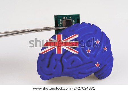 On a white background, a model of the brain with a picture of a flag - New Zealand, a microcircuit, a processor, is implanted into it. Close-up