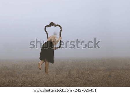 
surreal journey of a woman who escapes from the real world through a frame immersed in fog, abstract concept Royalty-Free Stock Photo #2427026451