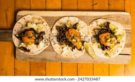Three mushroom tacos on a board