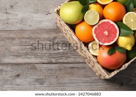 Different cut and whole citrus fruits on wooden table, top view. Space for text