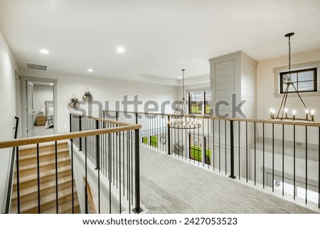 Entry entrance foyer hallway and stair case with wrought iron railings leading into a modern farmhouse style family home. Royalty-Free Stock Photo #2427053523