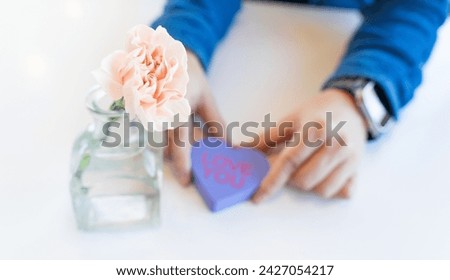 A man is holding a heart shape written with Love letter. A romantic moment for couples to share love on their wedding, valentine, anniversaries. There are photo and vector versions 
