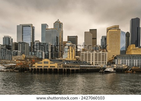 THE CITY OF SEATTLE SKYLINE WITH A CLOUDY SKY FROM ELLIOTT BAY