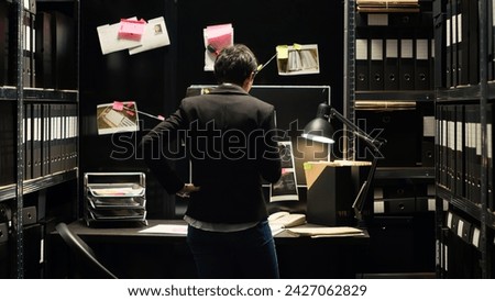 Private inspector analyzing case files, gathering intelligence to solve mistery crime. Criminologist inspecting clues, uncovering new proof to catch culprit in incident room. Handheld shot.