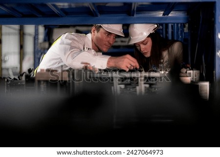 checking and inspecting metal machine part items for shipping. male and woman worker checking the store factory. industry factory warehouse. The warehouse of spare part for machinery and vehicles.