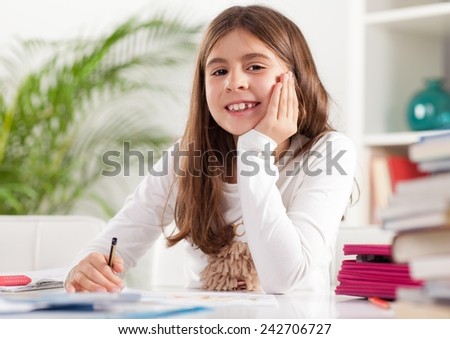 Cute little girl drawing. Elementary age.