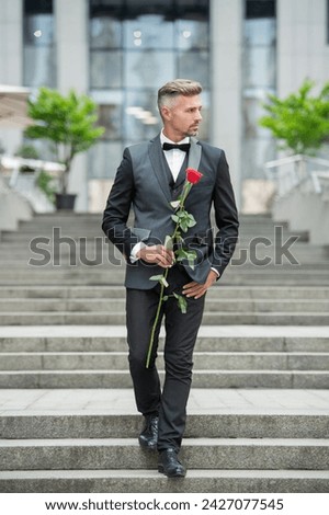 special occasion formalwear. grizzled man with rose for special occasion. tuxedo man outdoor Royalty-Free Stock Photo #2427077545
