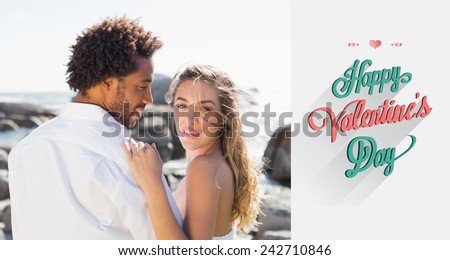 Gorgeous couple embracing by the coast against valentines day greeting