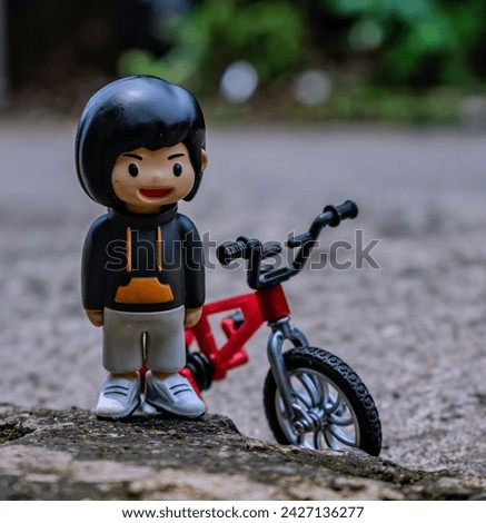 photo of a toy figure of a child on his BMX bike, selective focus, bokeh background