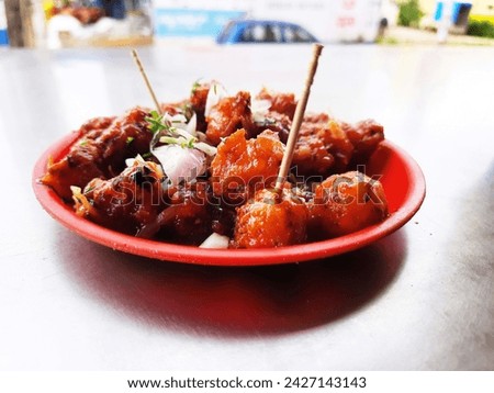 Closeup of hot and tasty Indian Gobi Manchurian snacks in a plate Royalty-Free Stock Photo #2427143143