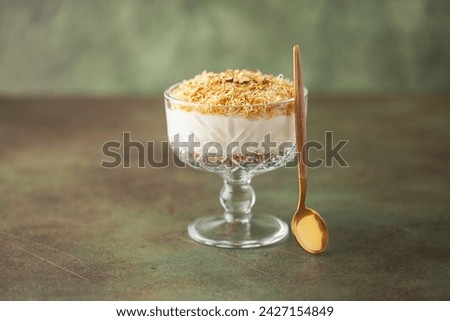 Traditional milky crispy Ramadan dessert custard pudding with roasted kadayif and diced pistachio . Kadayifli Muhallebi Royalty-Free Stock Photo #2427154849